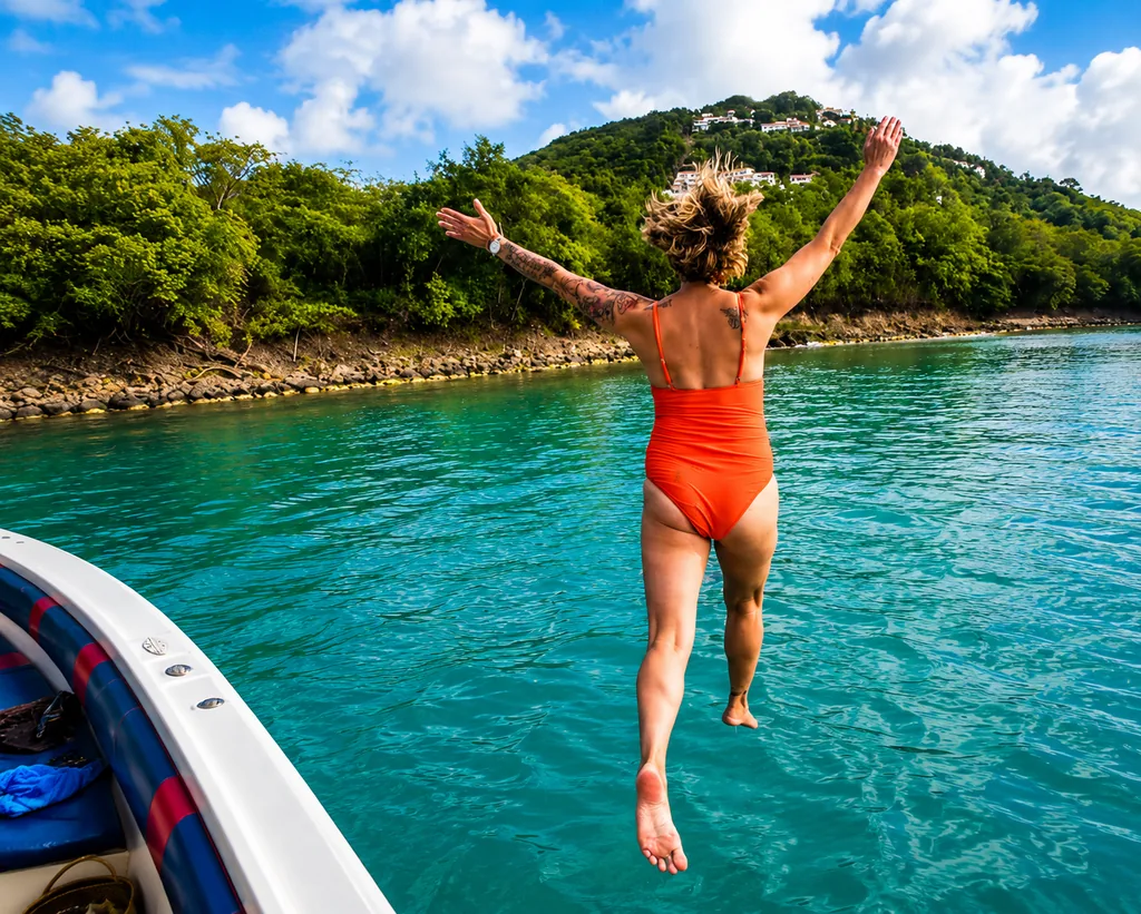 Guest jumping from the boat into turquoise water at a swim stop in St. Lucia