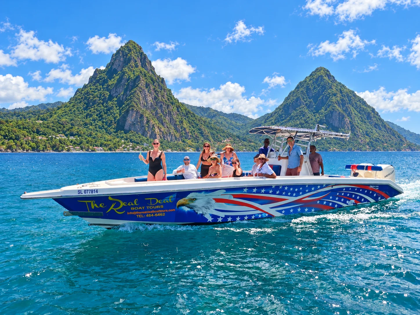 The Real Deal Boat Tours boat carrying guests on the Caribbean Sea with both Pitons side by side behind it, Saint Lucia